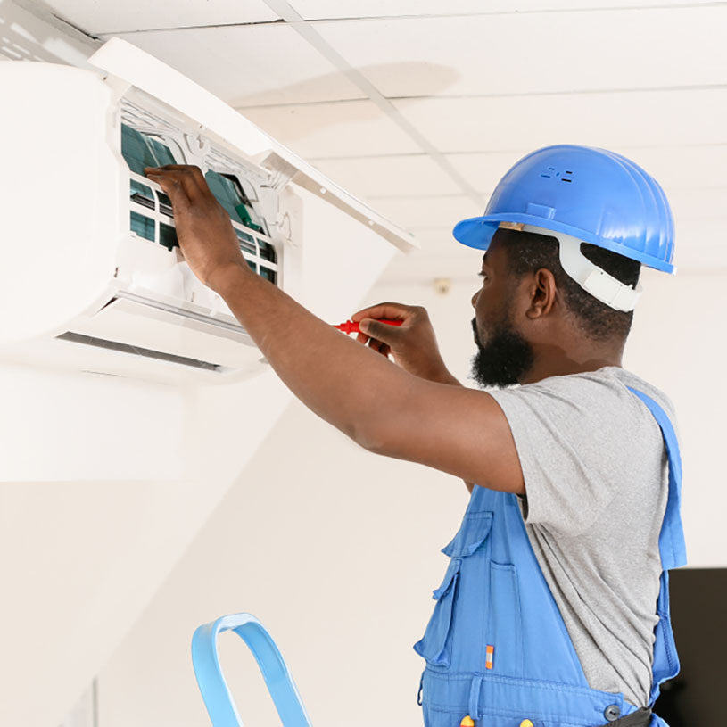 technician working on mini split with tools