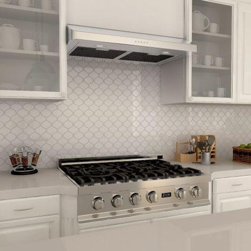a stove in a kitchen with a range hood installed above it