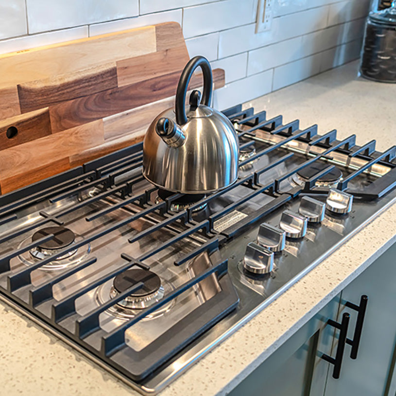 a kettle sitting on a five burner rangetop