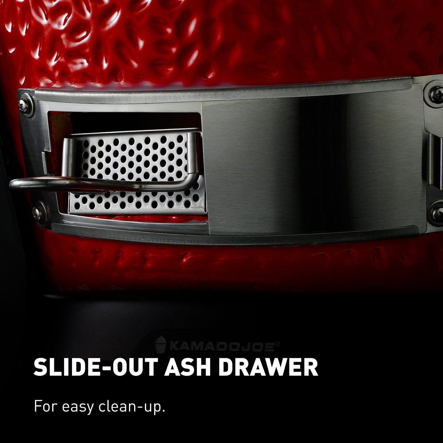 Slide-out ash drawer on a Kamado Joe grill with red ceramic surface
